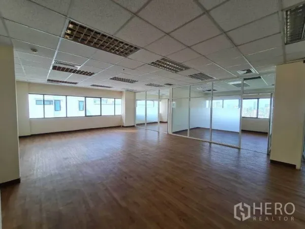 办公空间 出租在Watthana, Bangkok - 明亮工作区，整面窗户，侧边为磨砂玻璃会议室