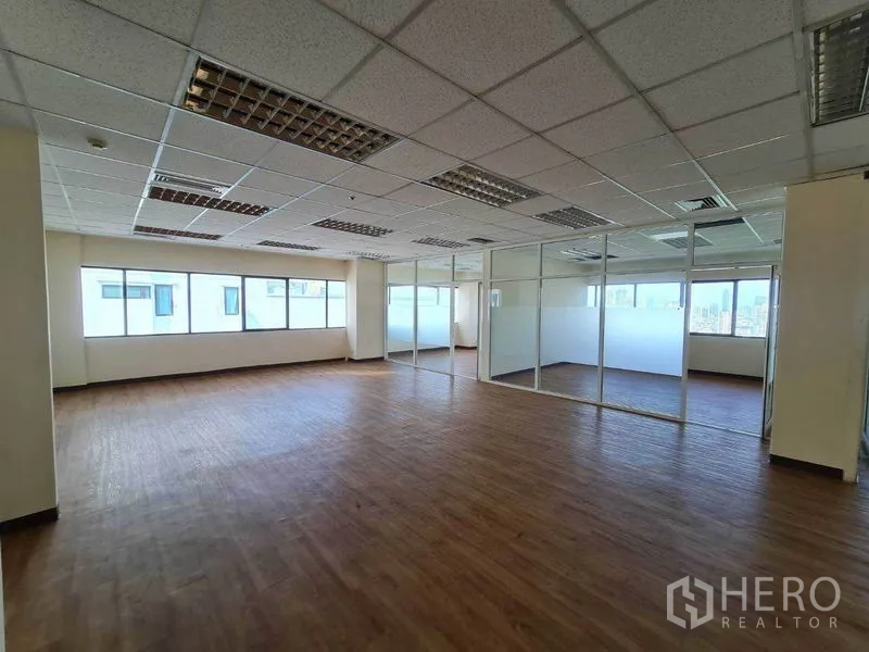 办公空间 出租在Watthana, Bangkok - 明亮工作区，整面窗户，侧边为磨砂玻璃会议室