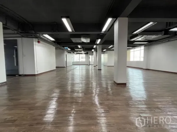 สำนักงาน ให้เช่าในRatchathewi, Bangkok - พื้นที่สำนักงานแบบเปิด โล้พื้นลายไม้ เพดานสีดำโชว์งาน ระบบไฟสว่าง เสากลาง และหน้าต่างบานใหญ่ปลายห้อง