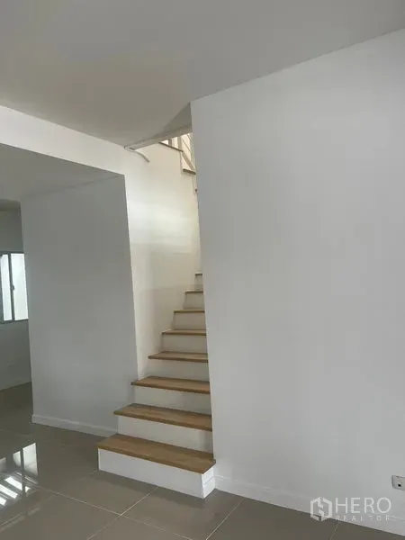 Townhouse for sale - White staircase with wooden treads leading to the upper floor