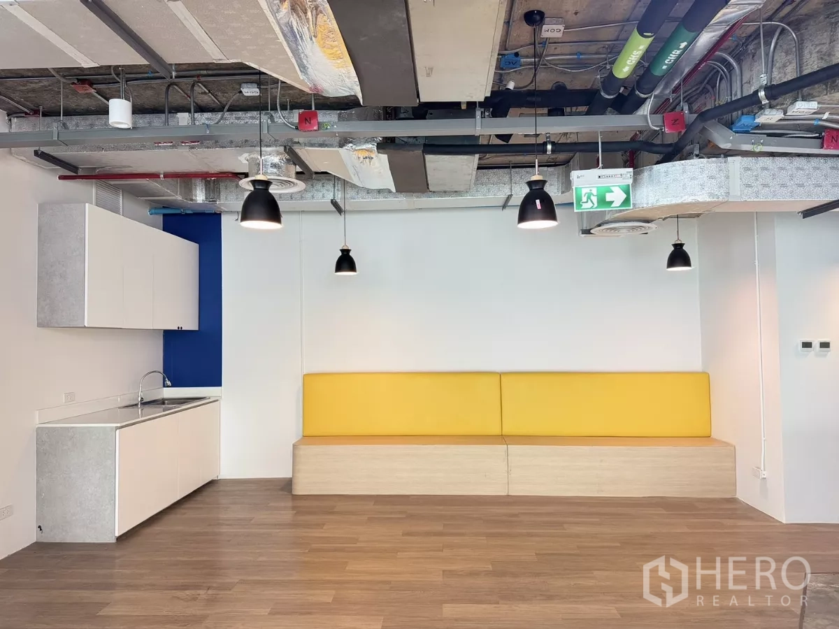 Office Space for rent in Din Daeng, Bangkok - Pantry and lounge with a yellow bench seat, pendant lighting, and wood floors.