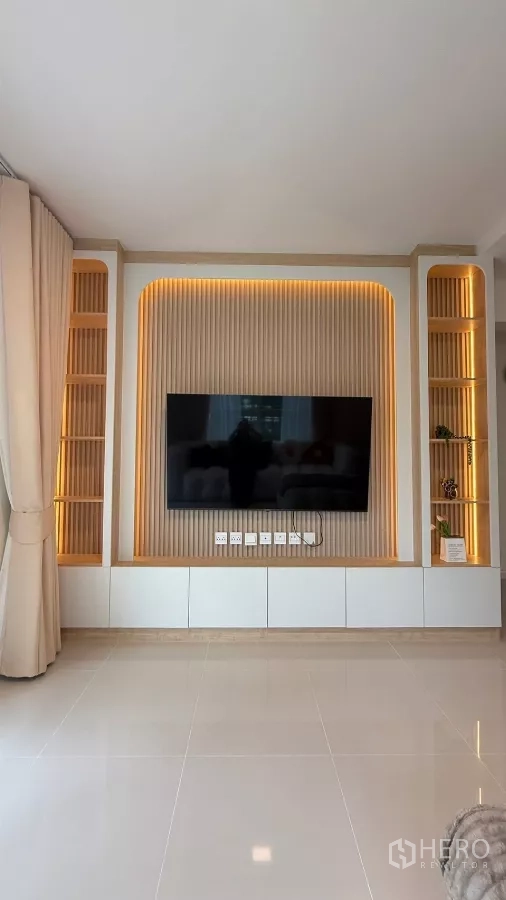 Detached House for rent in Bang Phli, Samut Prakan - Living room feature wall with built-in shelves and a mounted 65-inch TV.