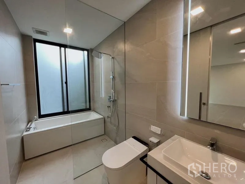 Detached House for rent or sale in Saphan Sung, Bangkok - Secondary bathroom with bathtub, rain shower, and modern fixtures.