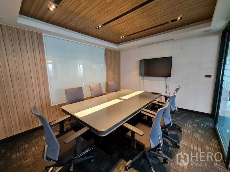 Office Space for rent - Conference room with TV display, glass walls, acoustic ceiling and ergonomic chairs.