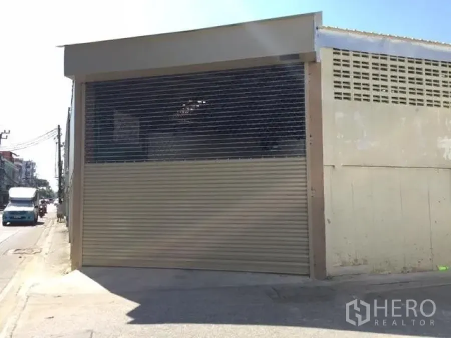 Warehouse for rent in Wang Thonglang, Bangkok - Street-facing warehouse facade with wide roller shutter and security grille in Wang Thonglang, Bangkok.