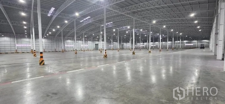 โรงงาน for rent in Si Racha, Chon Buri - ฮอลล์โกดังโล่งกว้างสว่างด้วยไฟ และพื้นคอนกรีตกว้าง.