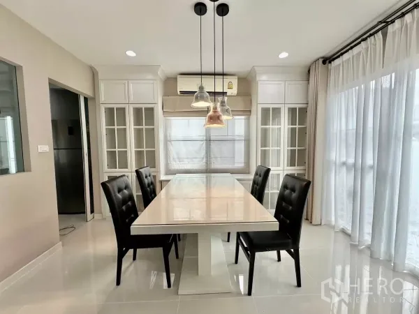 บ้าน ให้เช่าในBang Phli, Samut Prakan - พื้นที่รับประทานอาหารโต๊ะยาว โคมไฟแขวน และตู้กระจกบิวท์อิน