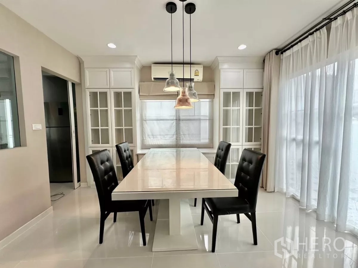 บ้าน ให้เช่าในBang Phli, Samut Prakan - พื้นที่รับประทานอาหารโต๊ะยาว โคมไฟแขวน และตู้กระจกบิวท์อิน