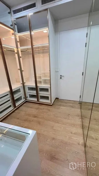 Condominium for rent in Watthana, Bangkok - Spacious walk-in closet with glass-front cabinetry and central island.