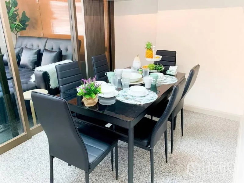 Home Office for rent in Khlong Toei, Bangkok - Dining area with six-seat table and black chairs beside a sliding glass partition.