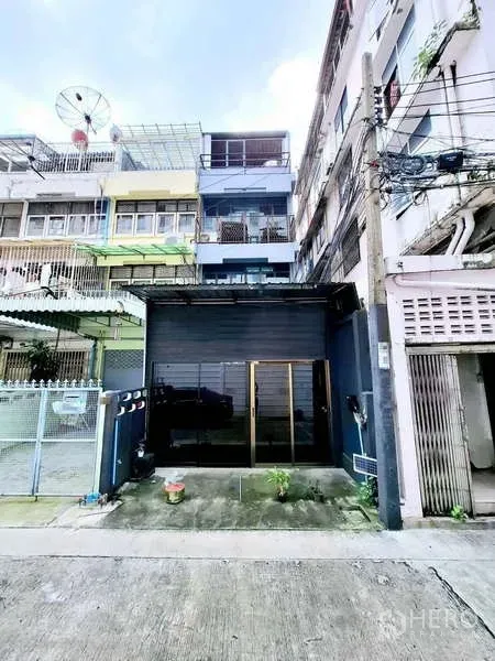 Shophouse for rent in Bang Rak, Bangkok - Shophouse exterior with black storefront and large glass doors on a quiet lane.