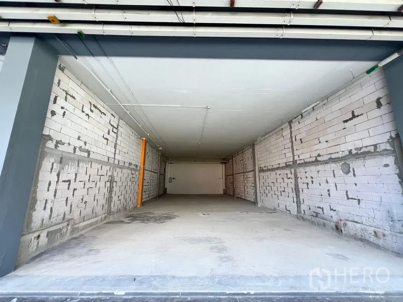 Retail Space for rent - Empty shell retail unit with wide frontage, bare brick walls, concrete floor and exposed ceiling services, ready for fit-out near BTS Phra Khanong.