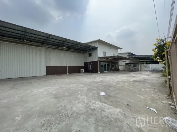 货栈 出租在Lat Lum Kaeo, Pathum Thani - 金属仓库与办公楼旁的宽大院场，配有遮棚便于卡车通行。