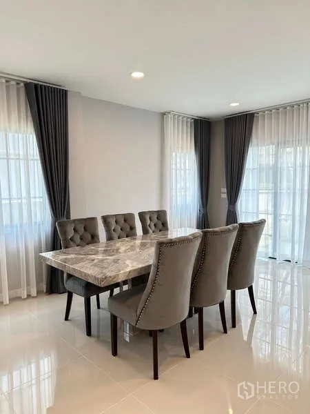 Detached House for rent in Bang Phli, Samut Prakan - Dining area with marble-top table and six tufted chairs by bright windows.