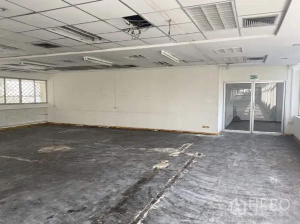 办公空间 出租在Khlong Toei, Bangkok - 带双开玻璃门的办公区，吊顶与未完成地面，便于自定义布局。