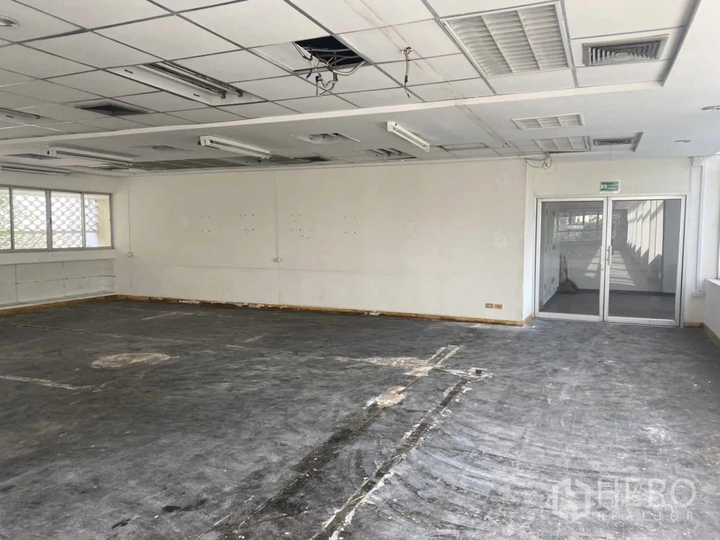 办公空间 出租在Khlong Toei, Bangkok - 带双开玻璃门的办公区，吊顶与未完成地面，便于自定义布局。