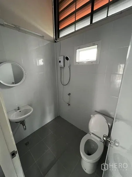 货栈 出租在Suan Luang, Bangkok - 整洁的瓷砖浴室，含马桶、洗手盆与壁挂式热水淋浴。
