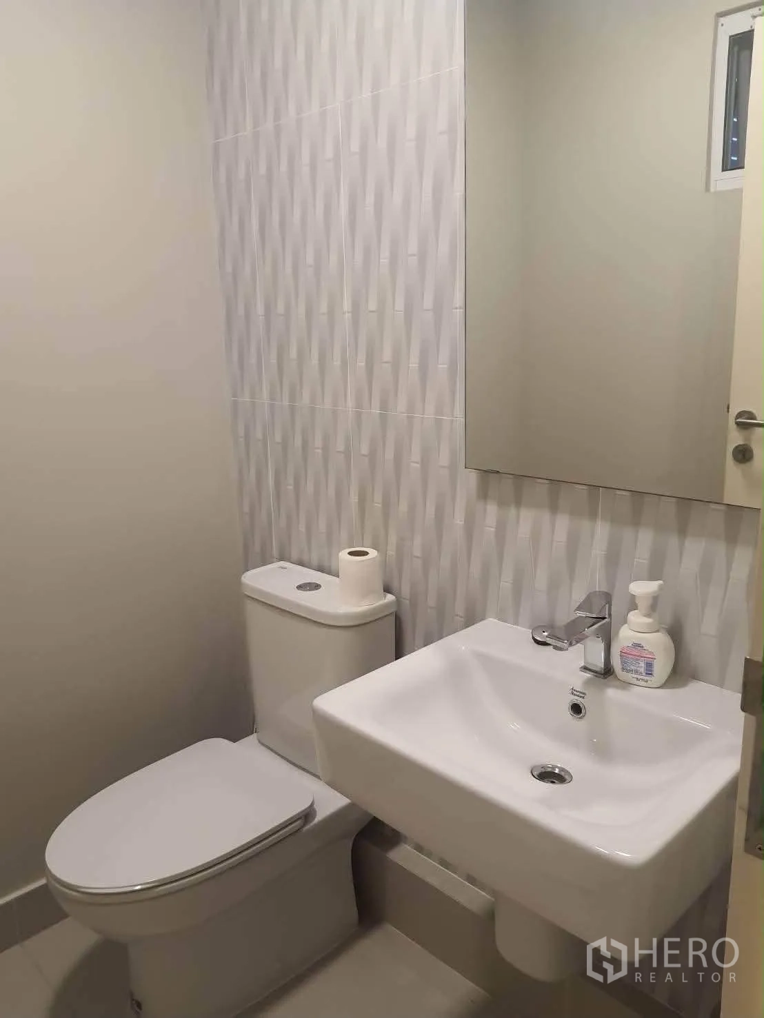 Townhouse for rent in Bang Phli, Samut Prakan - Clean bathroom with wall tile, mirror, toilet and basin.