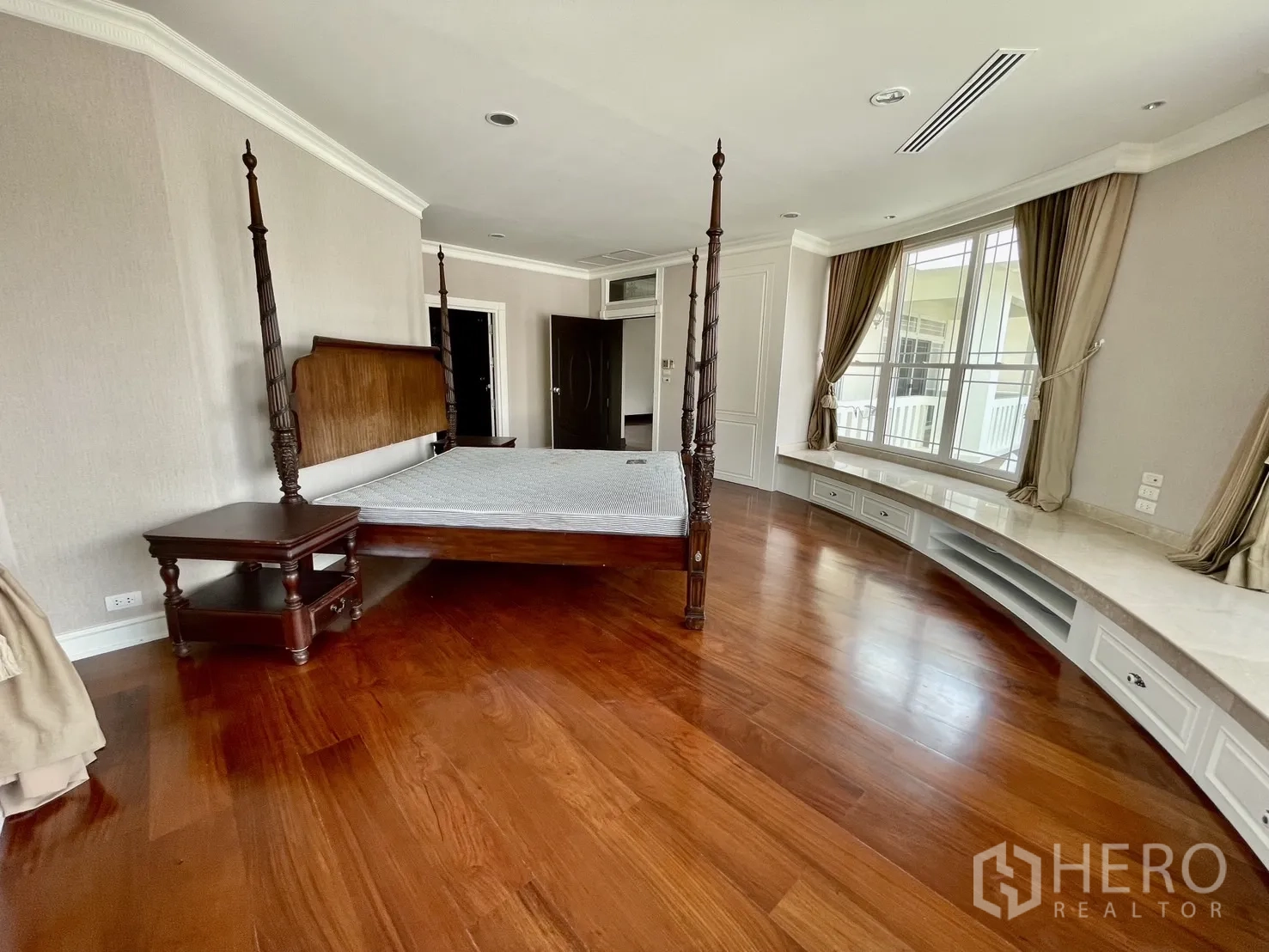 Detached House for rent in Chatuchak, Bangkok - Master bedroom with four-poster bed, curved bay windows and built-in bench.