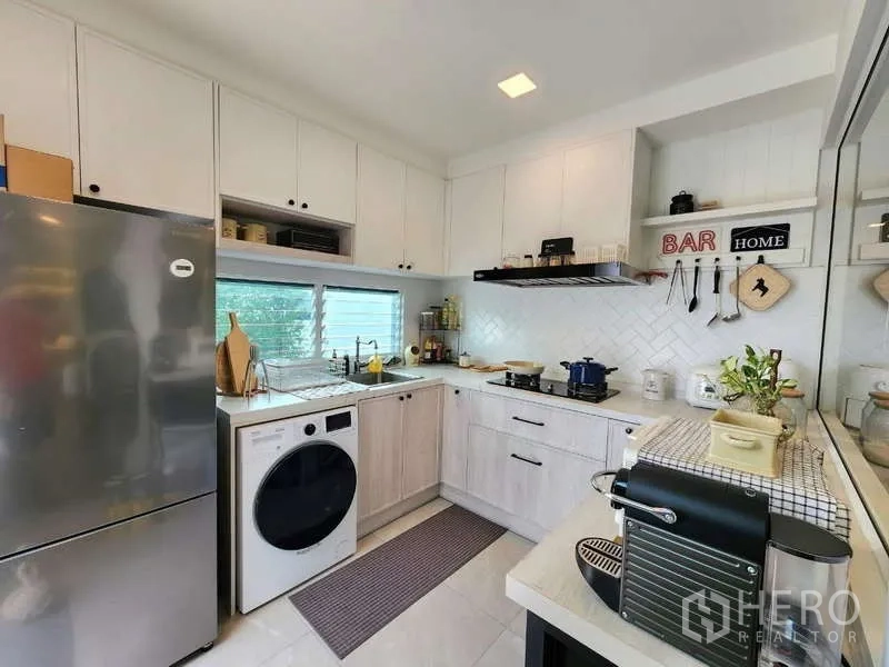 Detached House for rent or sale in Bang Phli, Samut Prakan - Kitchen view with stainless fridge, washer and extended counter space.