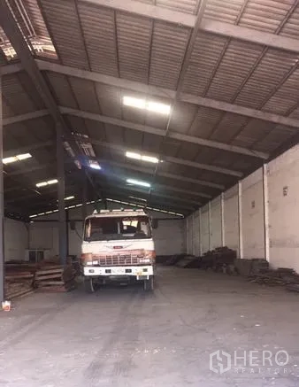货栈 出租在Chachoengsao - 仓库内部，高挑钢架屋顶与混凝土地坪，设采光天窗并停有卡车。