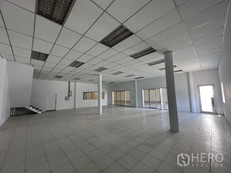 โรงงาน ให้เช่าในKhlong Luang, Pathum Thani - ออฟฟิศเปิดโล่ง มีเสา บันได และทางเข้าบานกระจกหลายจุด