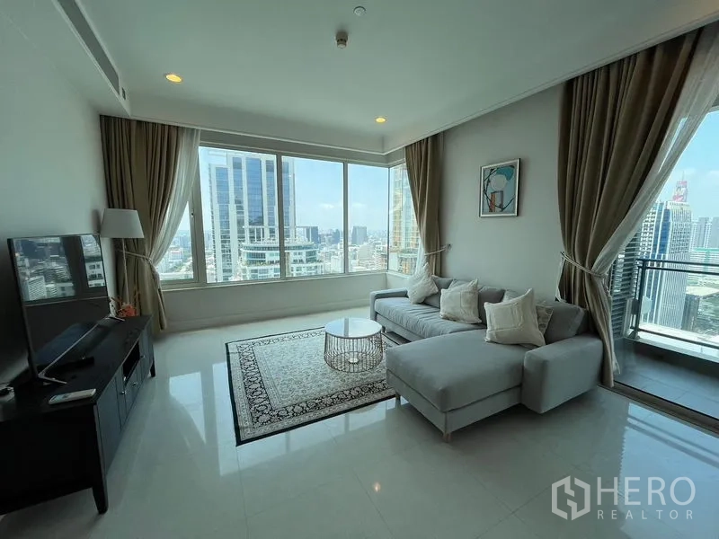 คอนโด ให้เช่าในPathum Wan, Bangkok - มุมห้องนั่งเล่นติดระเบียง โซฟาเข้ามุมและวิวเมืองพาโนรามา