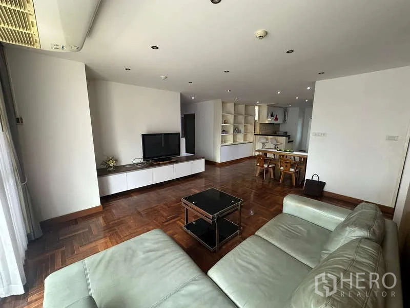 公寓 出租在Watthana, Bangkok - 客餐厅一体，内置置物架、餐桌与开放式厨房。
