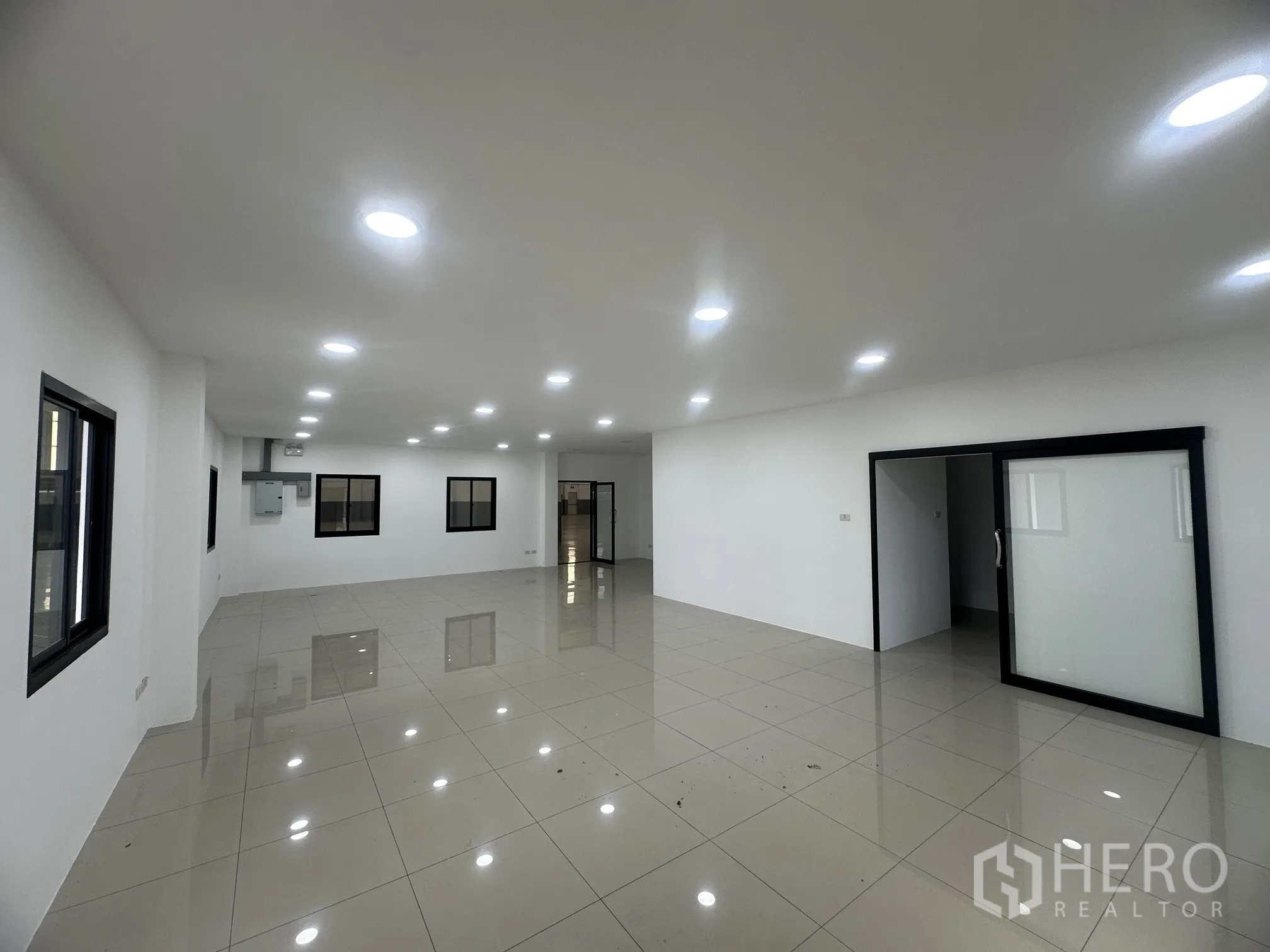 Factory for rent in Bang Phli, Samut Prakan - Bright tiled office interior with recessed lighting and sliding glass door.