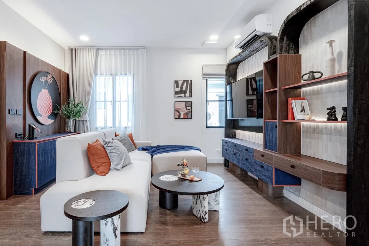 Detached House for rent in Saphan Sung, Bangkok - Family lounge with white sectional sofa, round coffee tables, and built-in media wall.
