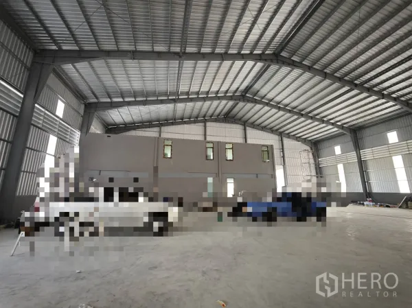 仓库 for rent or sale in Bang Phli, Samut Prakan - 从仓库大厅望向内部两层办公结构的视角。