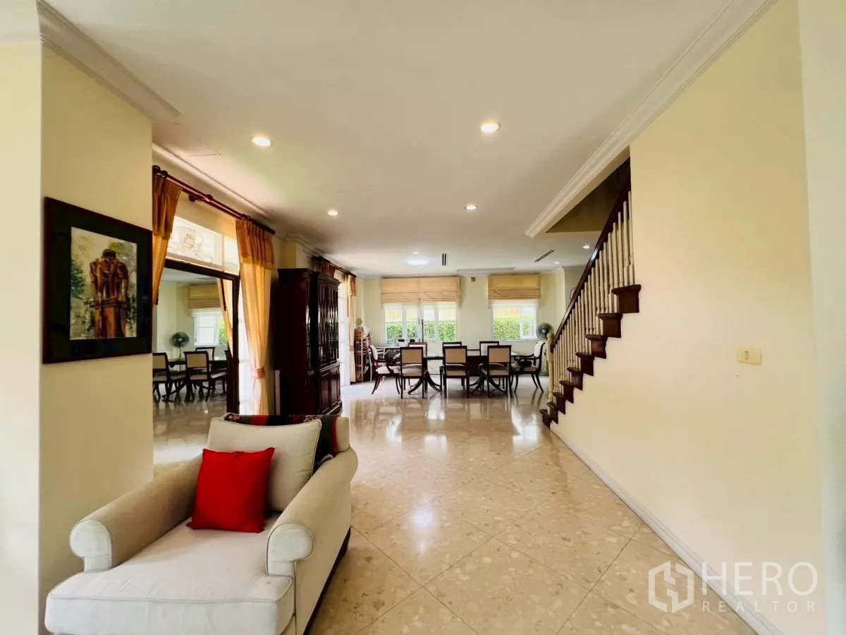 独立式住宅 出租在Prawet, Bangkok - 一层宽敞起居与用餐区，大窗与楼梯相伴。