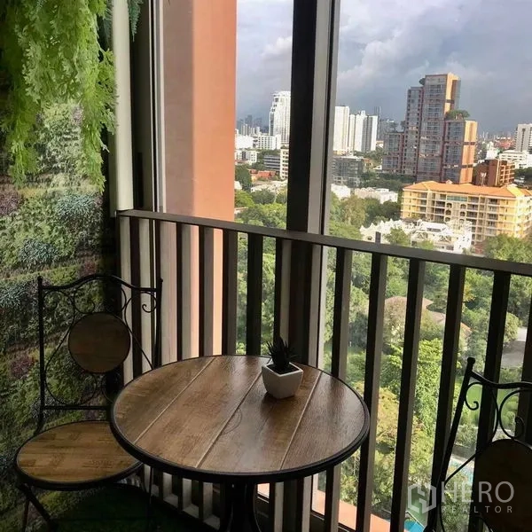 公寓 出租在Watthana, Bangkok - 阳台摆放休闲小圆桌，可俯瞰绿地与曼谷天际线。