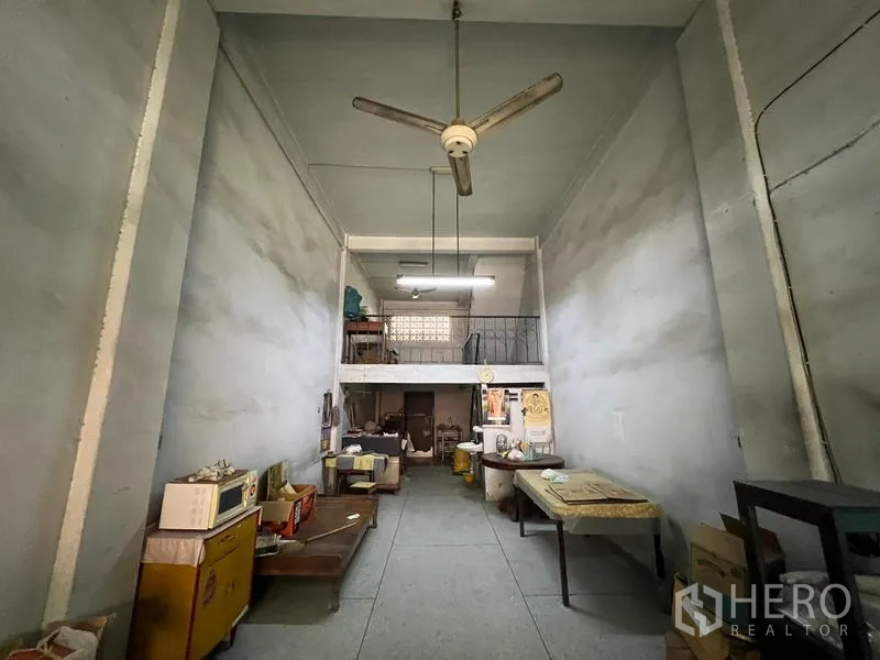 Shophouse for sale in Phra Khanong, Bangkok - Deep ground‑floor shop hall with high ceiling, mezzanine level and ceiling fan.