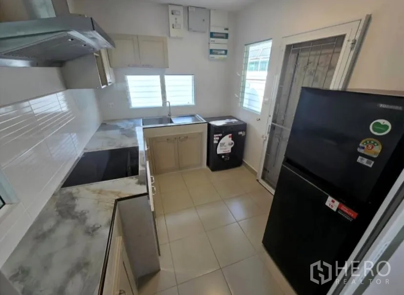 独立式住宅 for rent in Bang Phli, Samut Prakan - 紧凑厨房，带水槽、冰箱、洗衣机与后门。