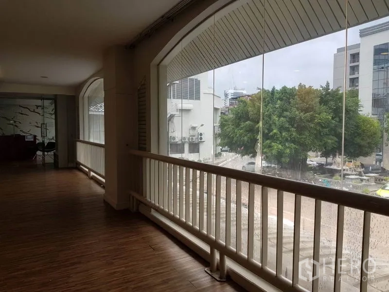 Retail Space for rent in Khlong Toei, Bangkok - Bright corridor with arched floor-to-ceiling windows overlooking the neighborhood, wood flooring and railing.