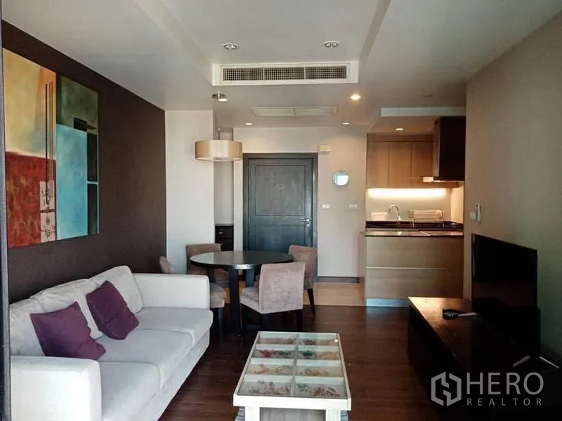 Condominium for rent in Sathon, Bangkok - Open-plan living and dining area with wood floors and recessed lighting adjoining the kitchen.