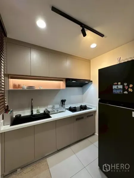 Townhouse for rent in Saphan Sung, Bangkok - Separate kitchen with gas hob, black sink, range hood and a tall refrigerator.