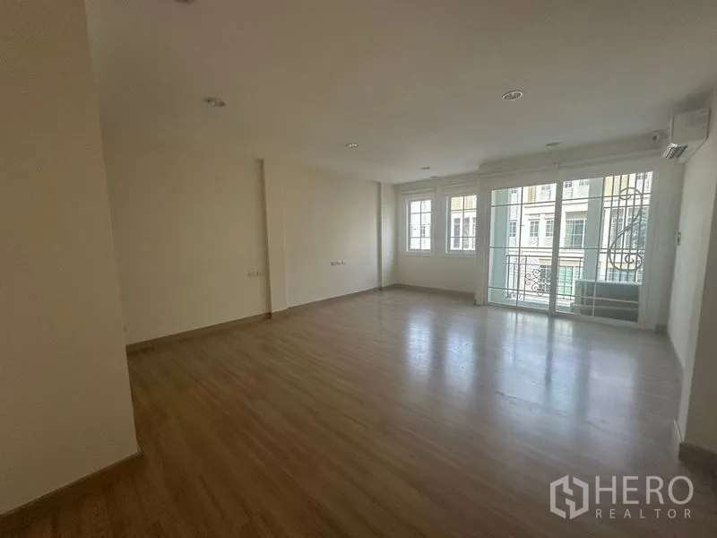 Home Office for rent in Bang Na, Bangkok - Spacious room view showing sliding doors to a small balcony and three windows.