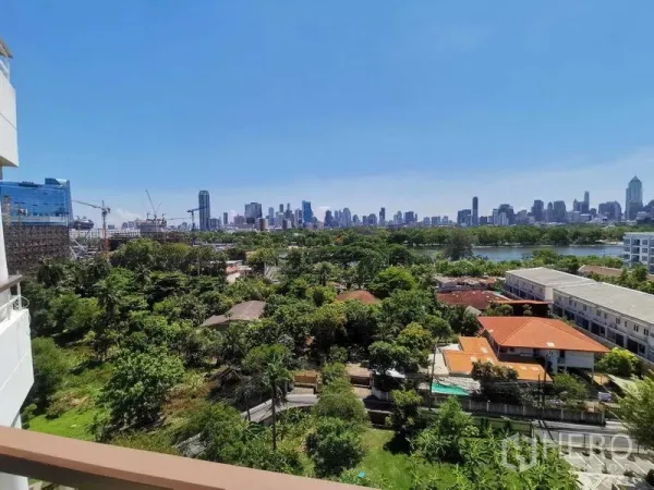 Condominium for rent in Khlong Toei, Bangkok - High‑floor balcony view of Bangkok skyline with Benjakitti Park’s lake and lush greenery.