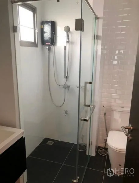 独立式住宅 出租在Lat Krabang, Bangkok - 小型浴室，玻璃淋浴间与座厕。