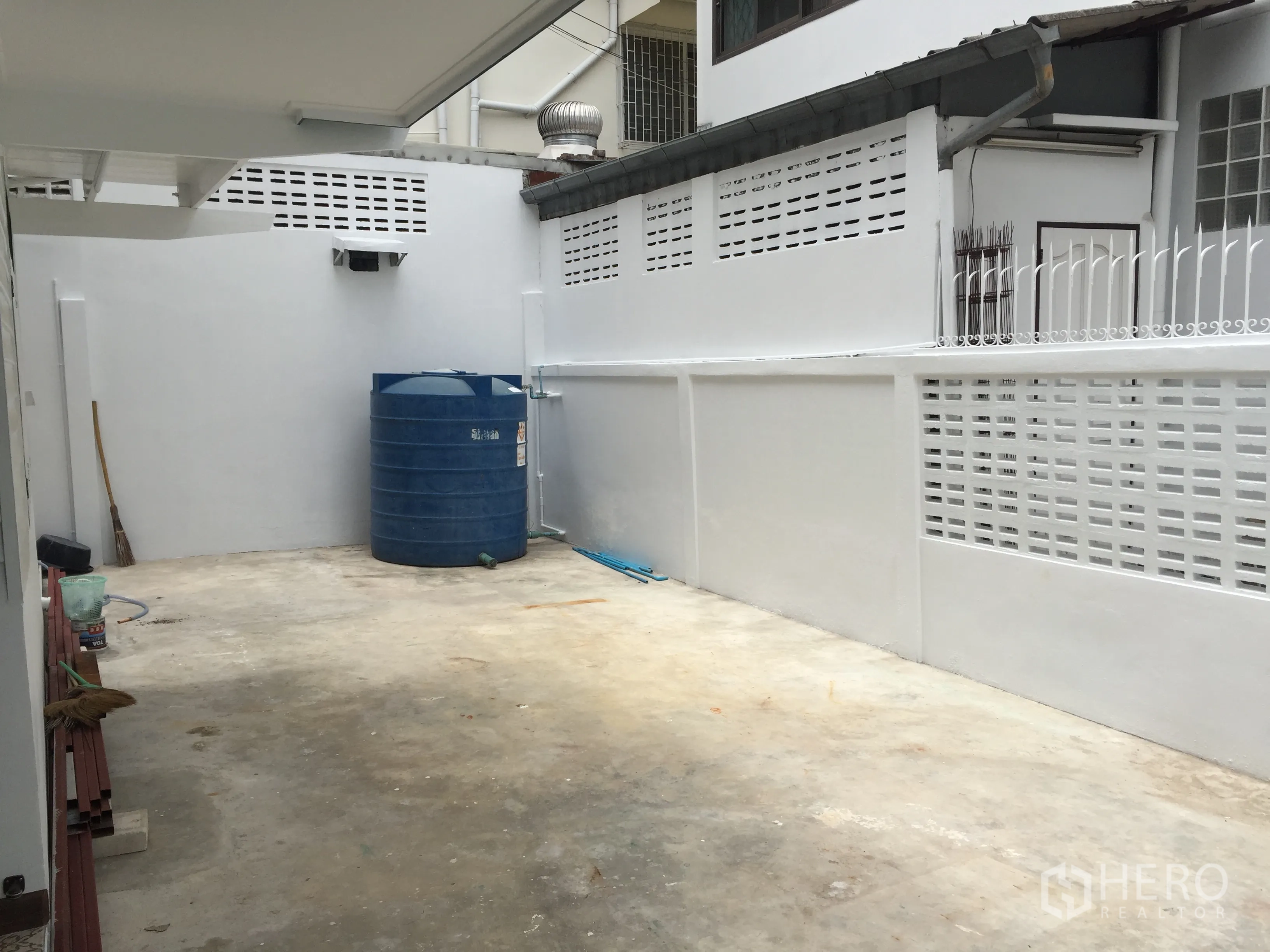 บ้าน ให้เช่าในBang Rak, Bangkok - ลานด้านข้างพื้นคอนกรีต มีกำแพงสูงและแท็งก์น้ำสีน้ำเงิน