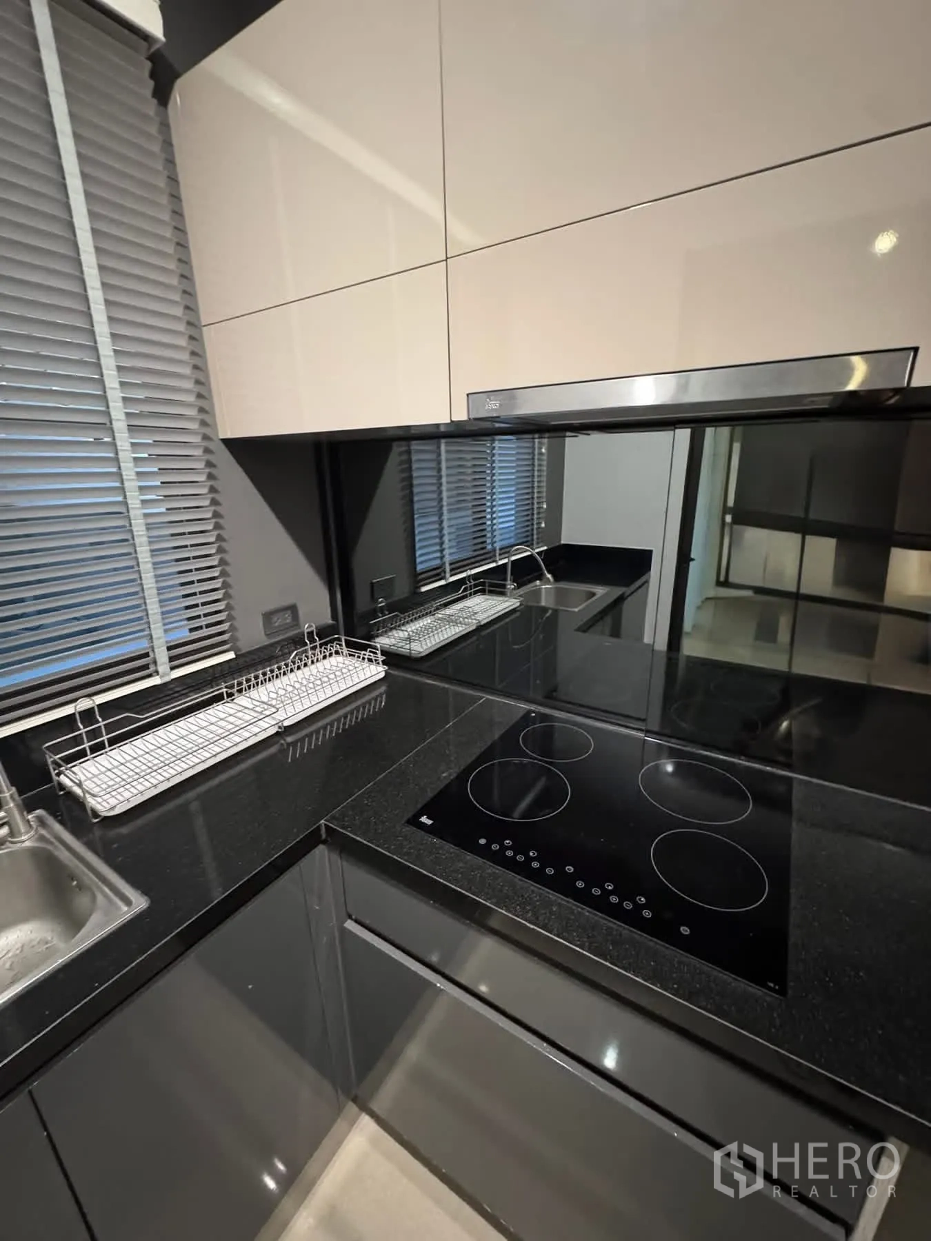 Townhouse for rent or sale in Lat Phrao, Bangkok - Modern kitchen corner with induction hob and black granite countertop.