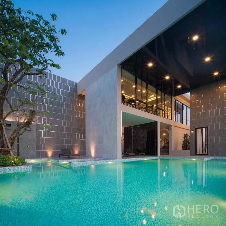 Detached House for rent in Saphan Sung, Bangkok - Contemporary clubhouse with illuminated swimming pool and glass-walled fitness room.