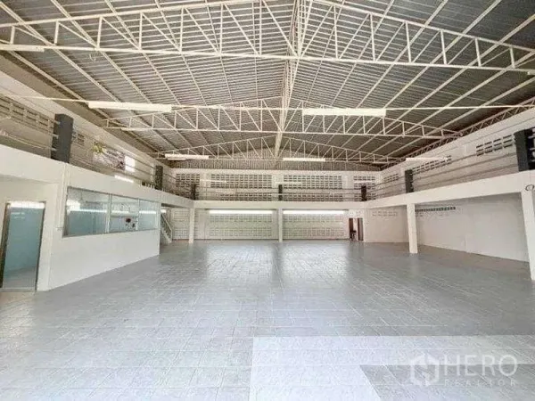Warehouse for rent in Bang Phli, Samut Prakan - Wide clear-span warehouse hall with bright lighting and glass-fronted office.