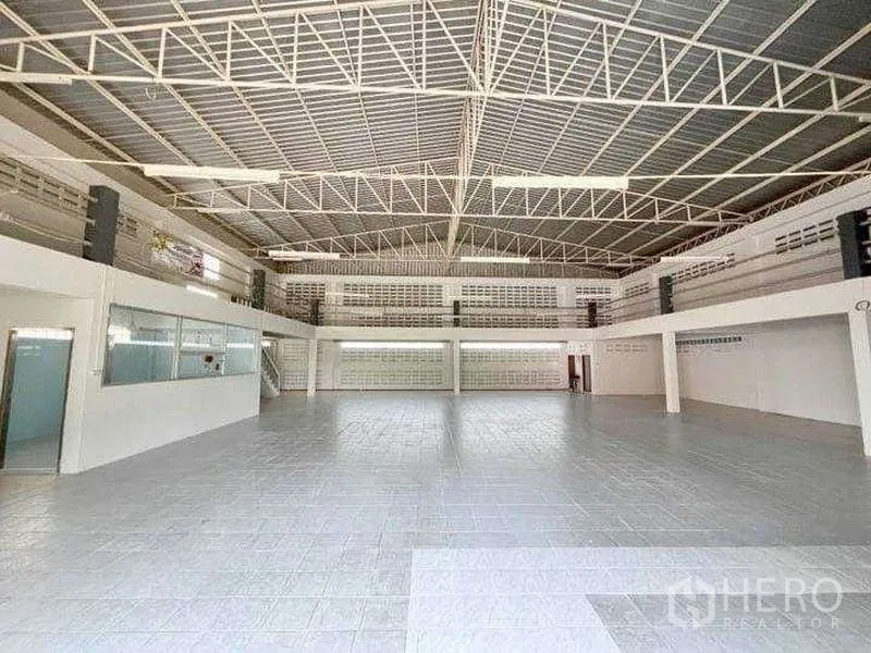 Warehouse for rent in Bang Phli, Samut Prakan - Wide clear-span warehouse hall with bright lighting and glass-fronted office.