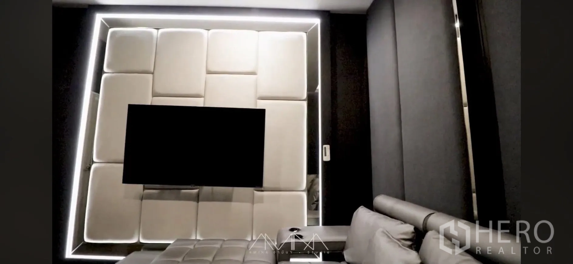 Detached House for rent in Saphan Sung, Bangkok - Media room with padded wall panel, mounted TV, and gray leather sofa.