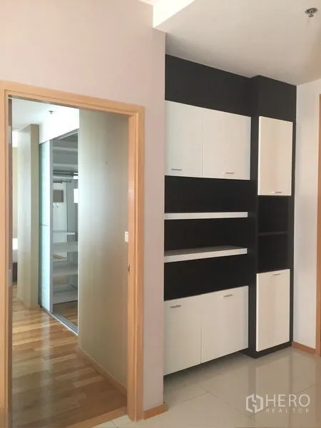 Condominium for rent - Hallway with black and white built-in shelving and doorway to bedrooms.