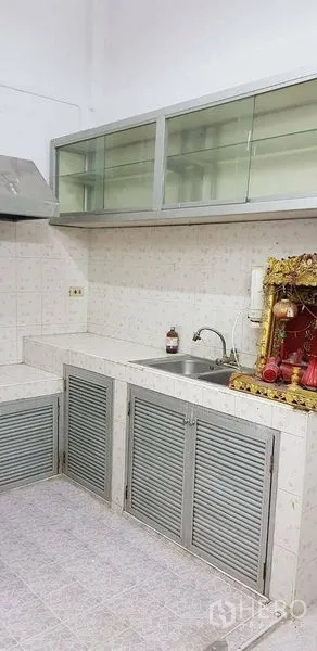 带办公室的家 出租或出售在Bang Na, Bangkok - 紧凑厨房，带水槽、抽油烟机与玻璃吊柜。