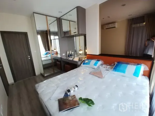 公寓 出租在Huai Khwang, Bangkok - 明亮卧室，配大床、镜面衣柜、梳妆台与大窗。